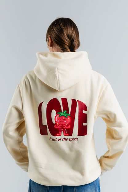 Person wearing a cream hoodie with a red 'LOVE' graphic and text on the back against a light gray background#color_cream